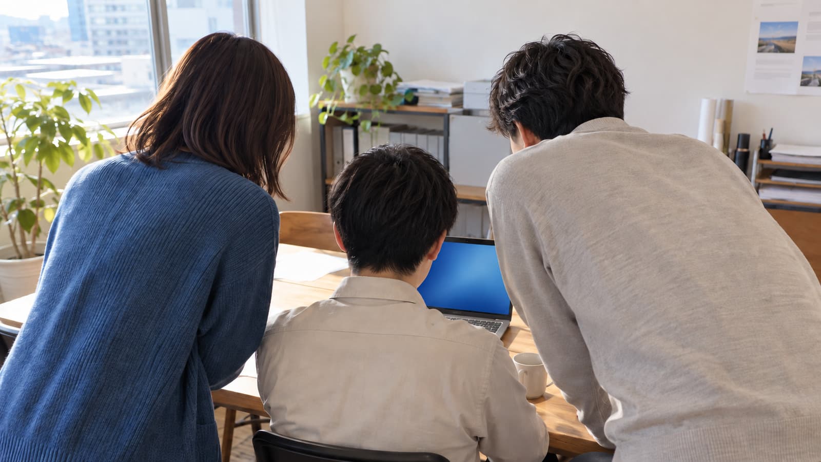 会議室で一人の社員がAIを使いこなし、まわりの同僚がその画面を覗き込む様子を、瑠璃色を差し色にしたドキュメンタリー風写真で表現