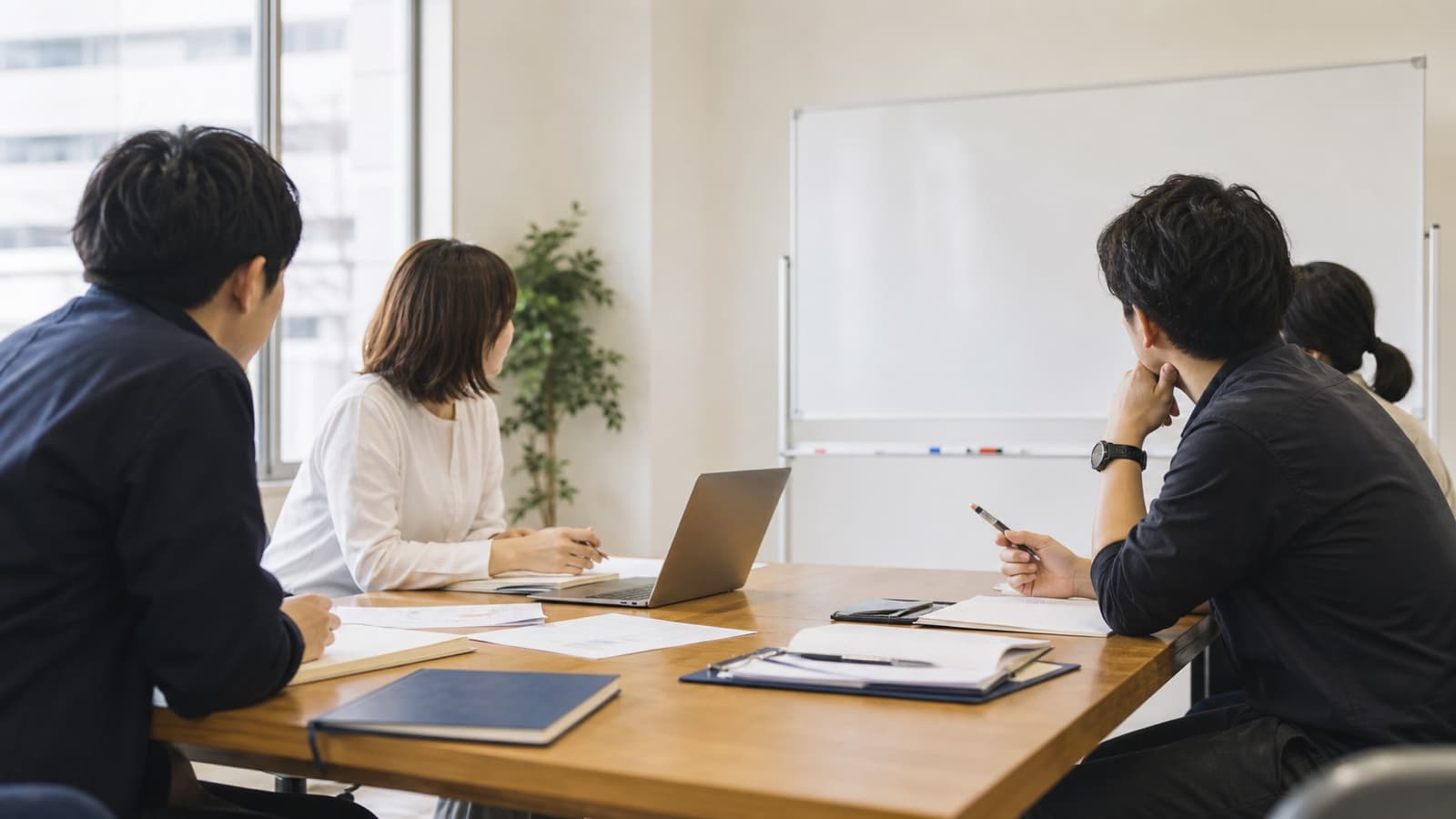 日本の中小企業の会議室で、録音から議事録が自動でまとまるイメージ